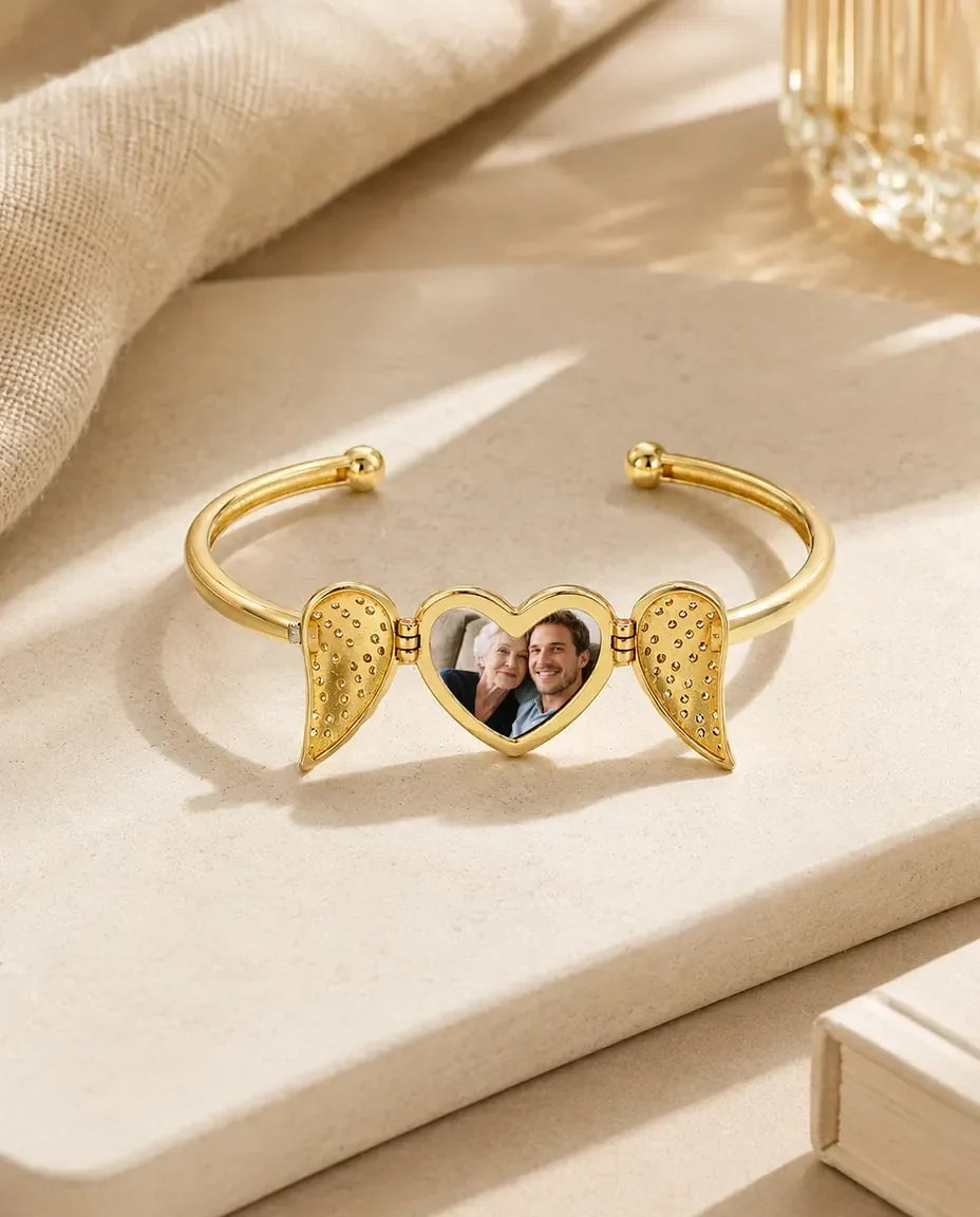 Gold heart photo bangle with angel wings opened to reveal the photo