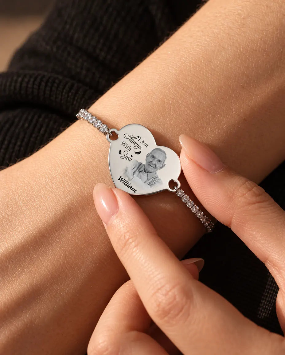 Fingertips holding the engraved photo heart on the silver tennis bracelet