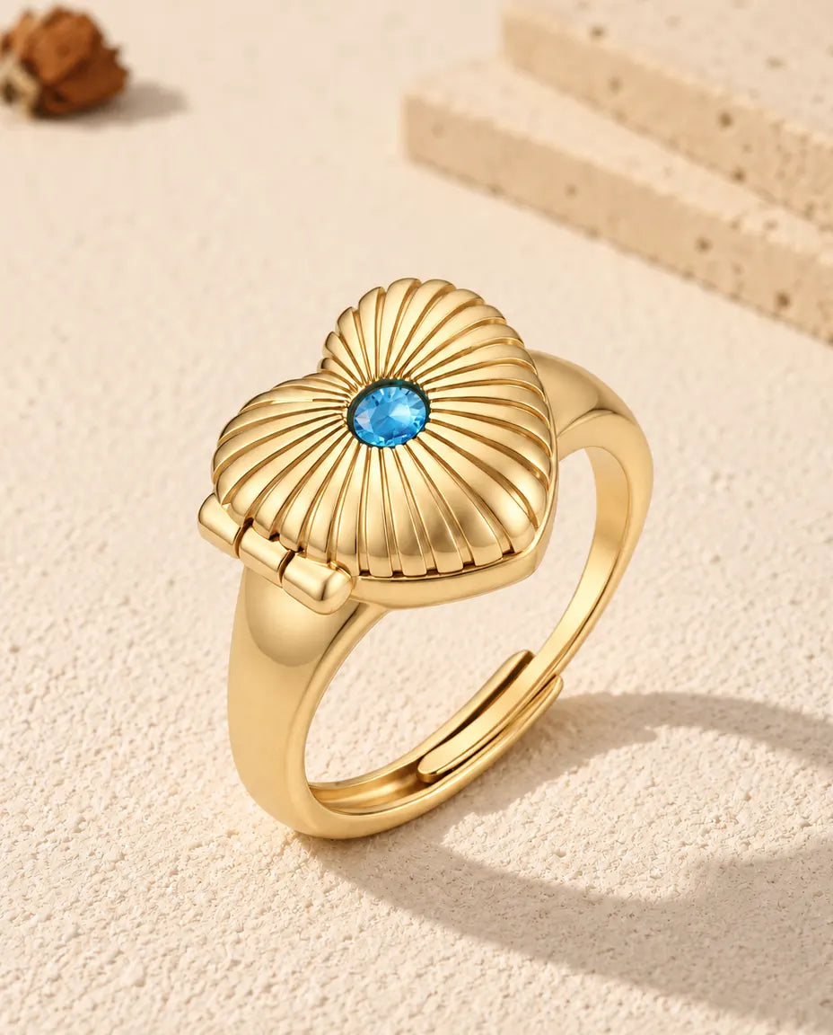 Personalized heart photo locket ring in gold tone with a blue birthstone on the fluted lid