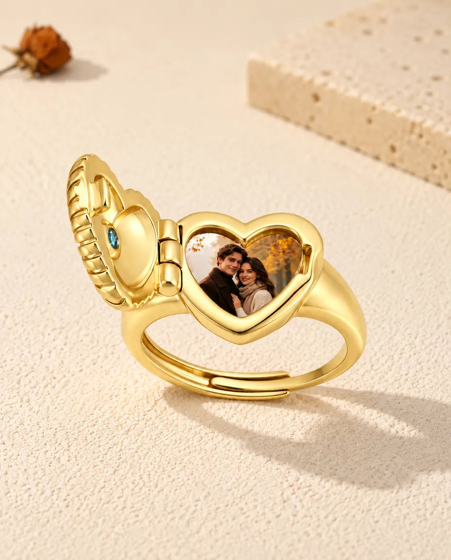 Heart locket ring opened to show a printed couple photo inside the heart frame