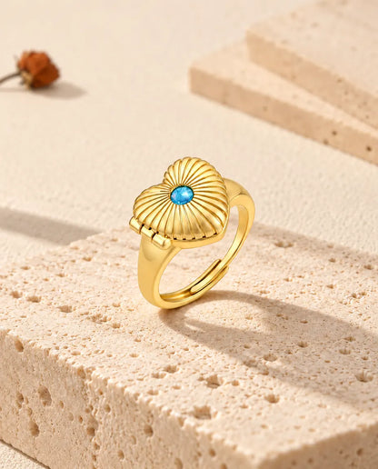 Closed heart locket ring standing on a travertine block