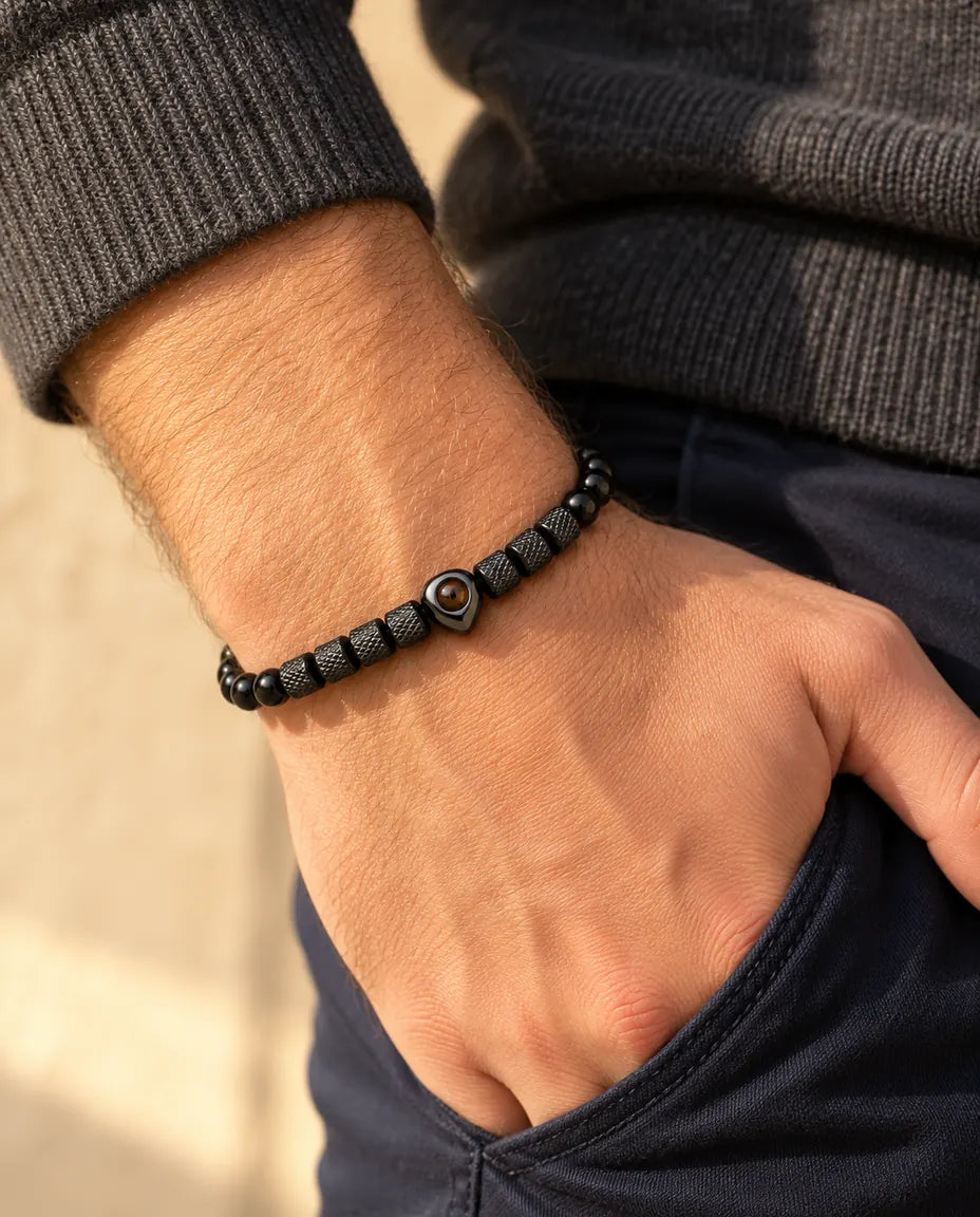 Man wearing the black heart photo projection bead bracelet, thumb hooked in his pocket