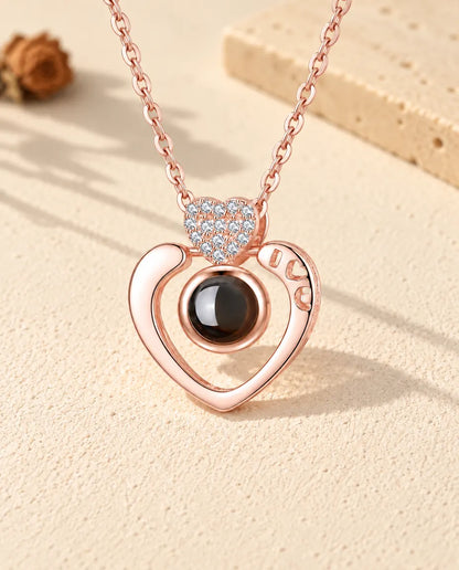 Front view of the rose gold tone open heart photo projection necklace
