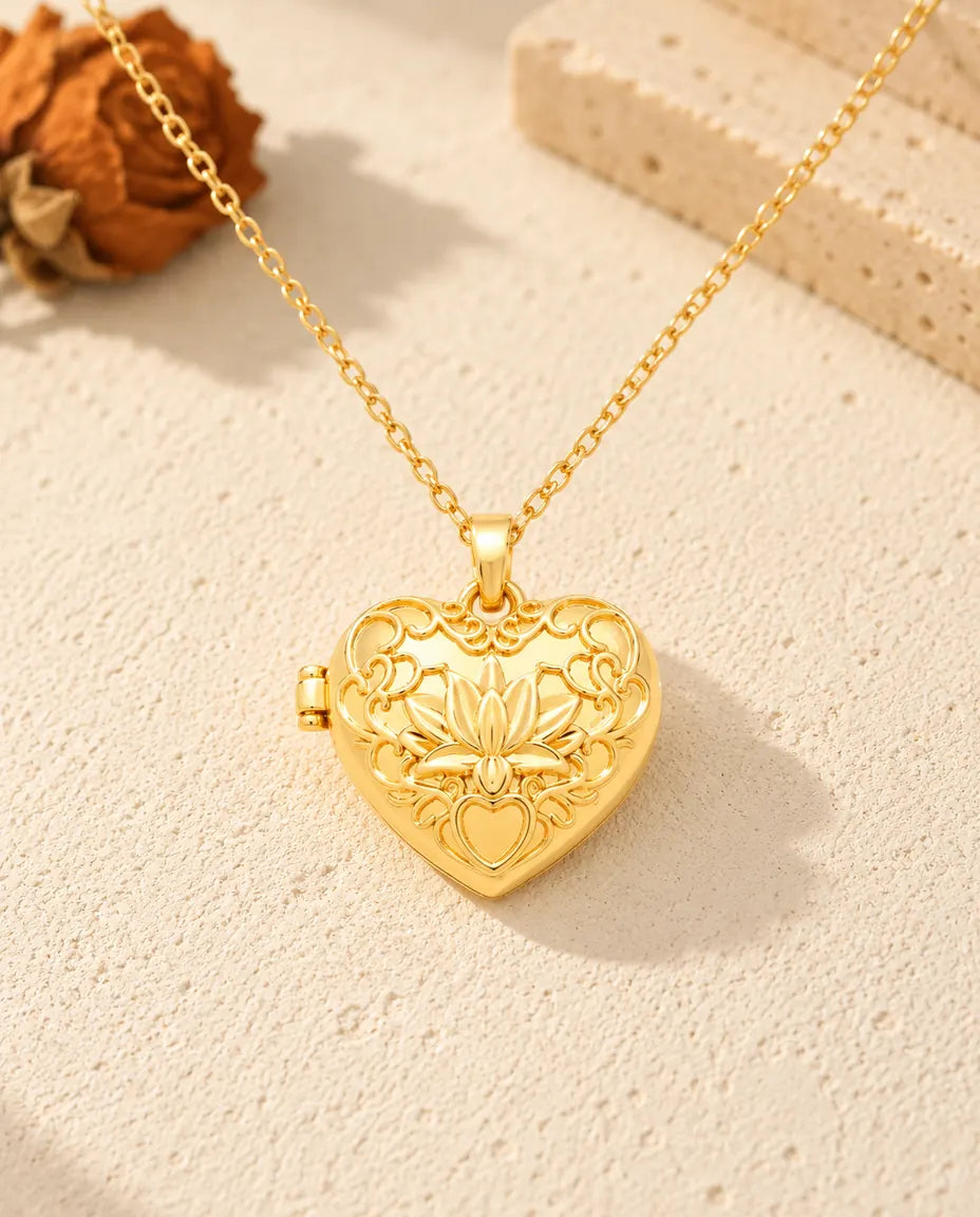 Front view of the gold tone lotus flower heart locket showing the lid design and side hinge