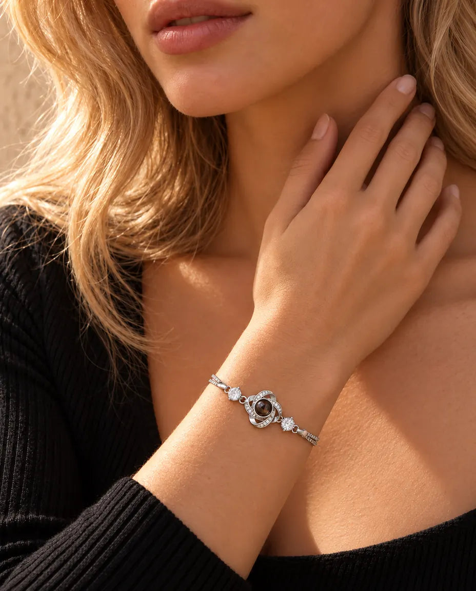 Woman touching the side of her neck, wearing the silver tone love knot projection bracelet