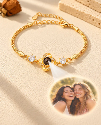 Light through the brown stone of the gold tone love knot charm projects a round photo of two laughing friends
