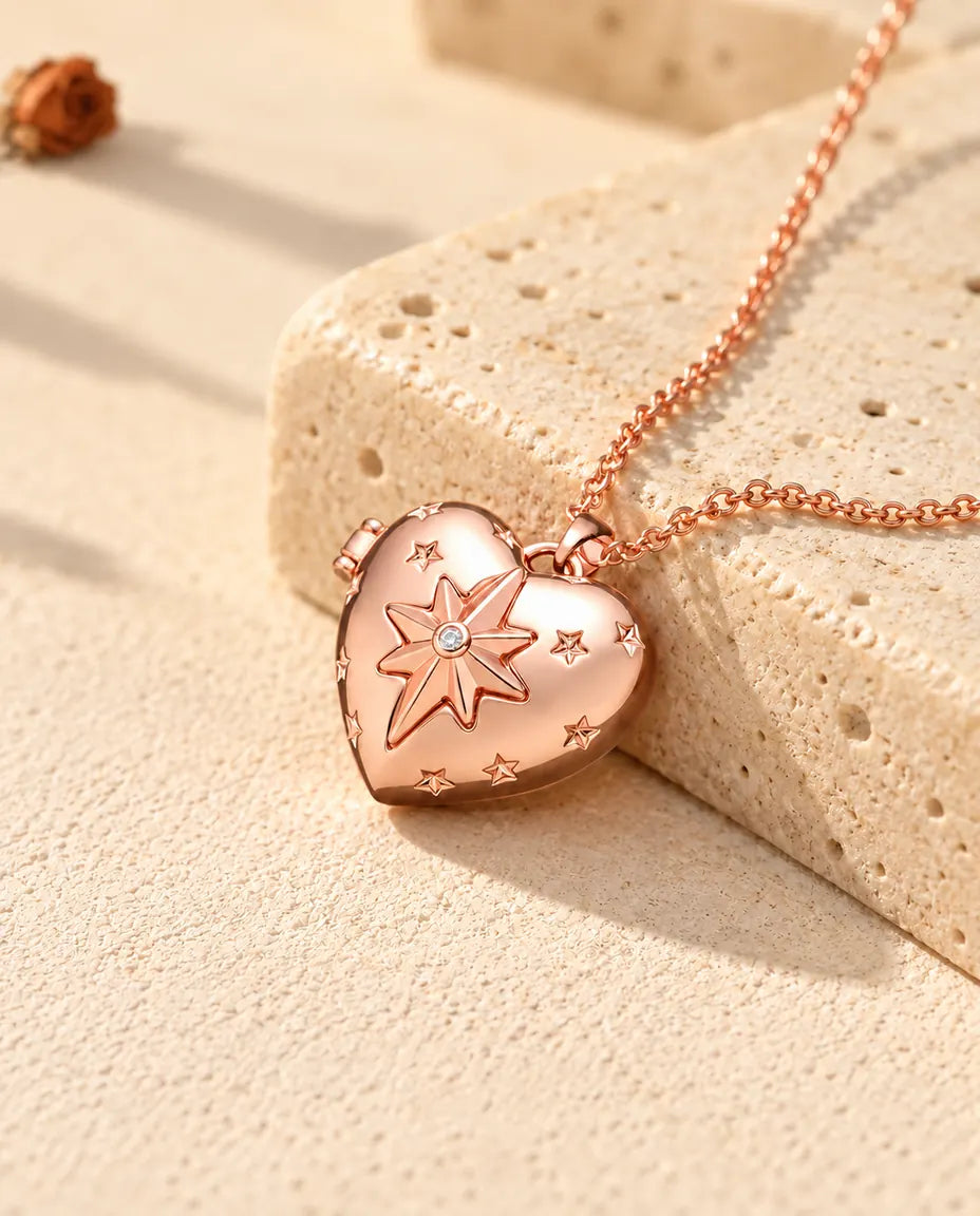 Rose gold tone north star heart photo locket necklace on travertine in warm sunlight