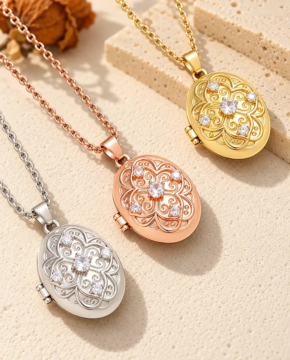 Oval filigree photo lockets in silver, rose gold tone and gold tone laid diagonally on cream plaster