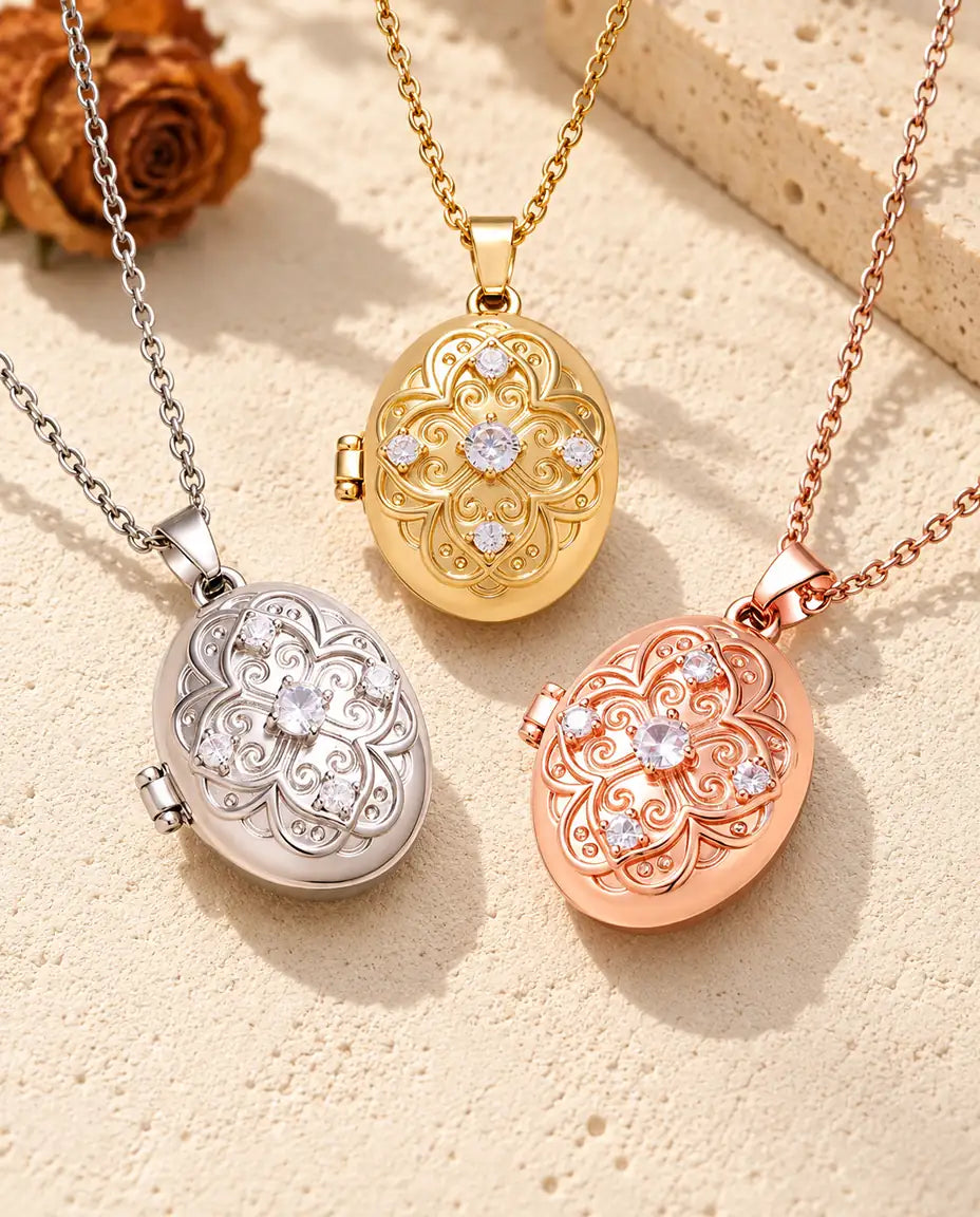 Three colors of the oval filigree photo locket necklace arranged on plaster