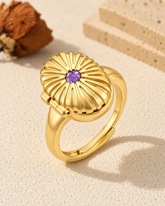Personalized oval photo locket ring in gold tone with a purple birthstone on the fluted lid
