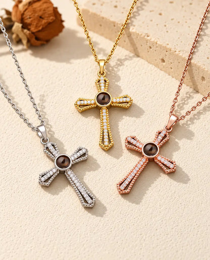 Three colors of the pave cross photo necklace laid out on cream plaster