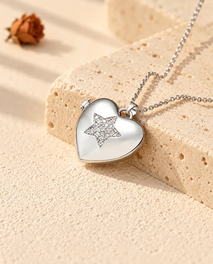Personalized pave star heart photo locket necklace in silver tone with a cubic zirconia star, resting on a travertine block