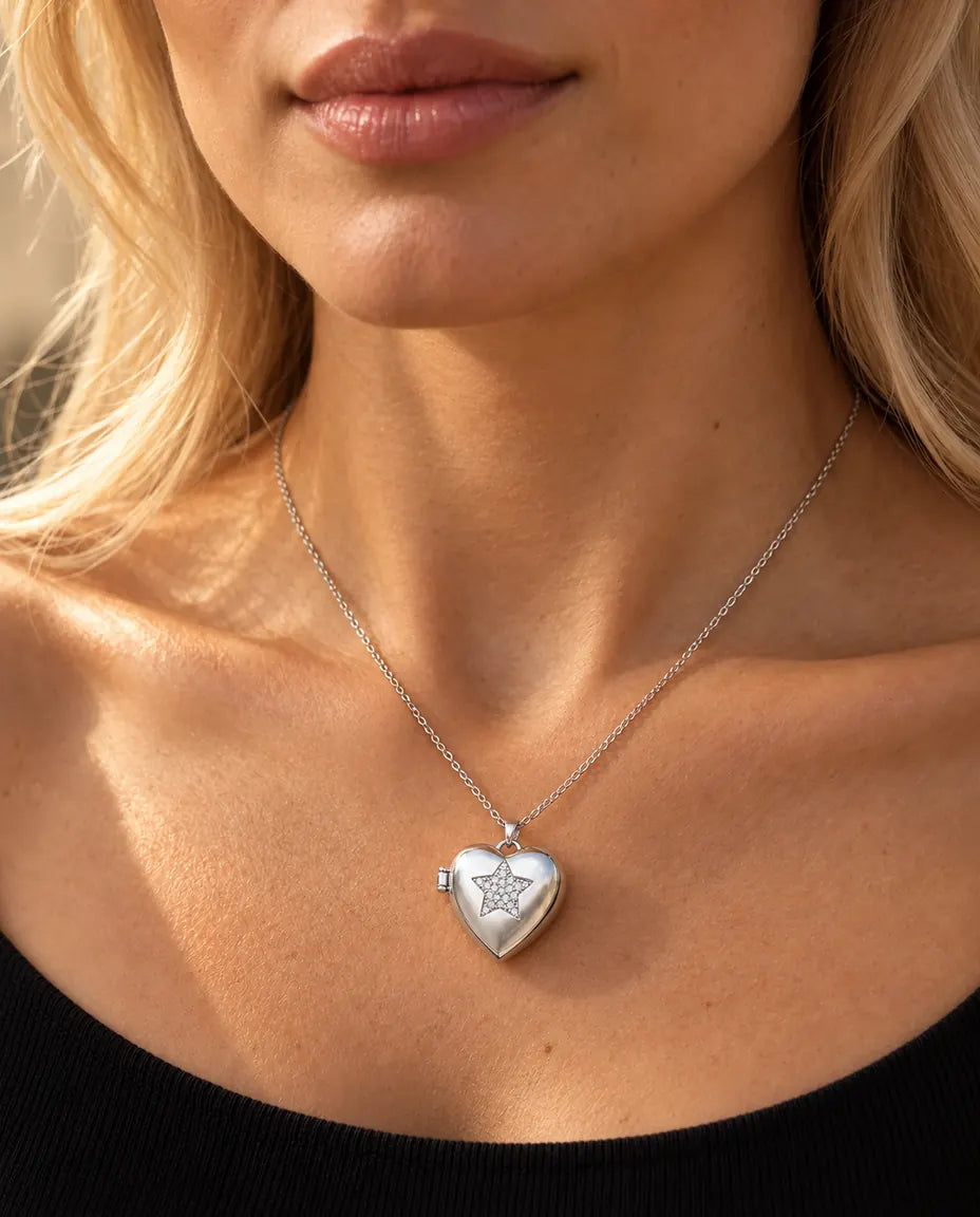 Woman in a black knit top wearing the silver tone pave star heart photo locket necklace