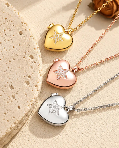 Gold tone, rose gold tone and silver tone pave star heart photo lockets stacked beside a travertine slab