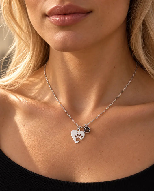Woman in a black knit top wearing the silver tone paw print heart pet photo necklace