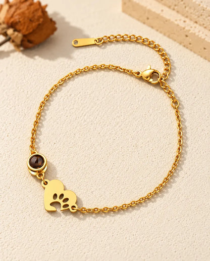 Gold tone pet memorial bracelet with a paw print heart tag and extender chain