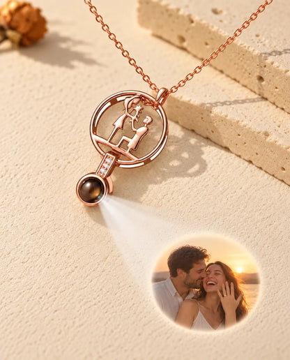 Rose gold tone proposal necklace projecting an engaged couple photo onto plaster
