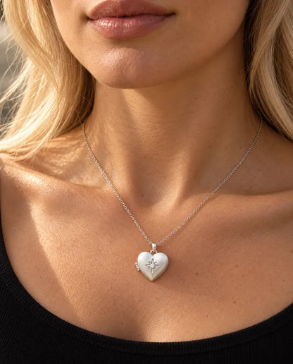 Woman in a black knit top wearing the silver tone satin flower heart photo locket necklace