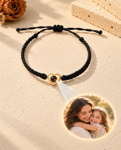 Light through the brown stone of the gold tone open heart projects a round mother and daughter photo onto the plaster