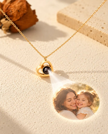 Gold tone double heart projection necklace shining a mother and daughter photo onto cream plaster