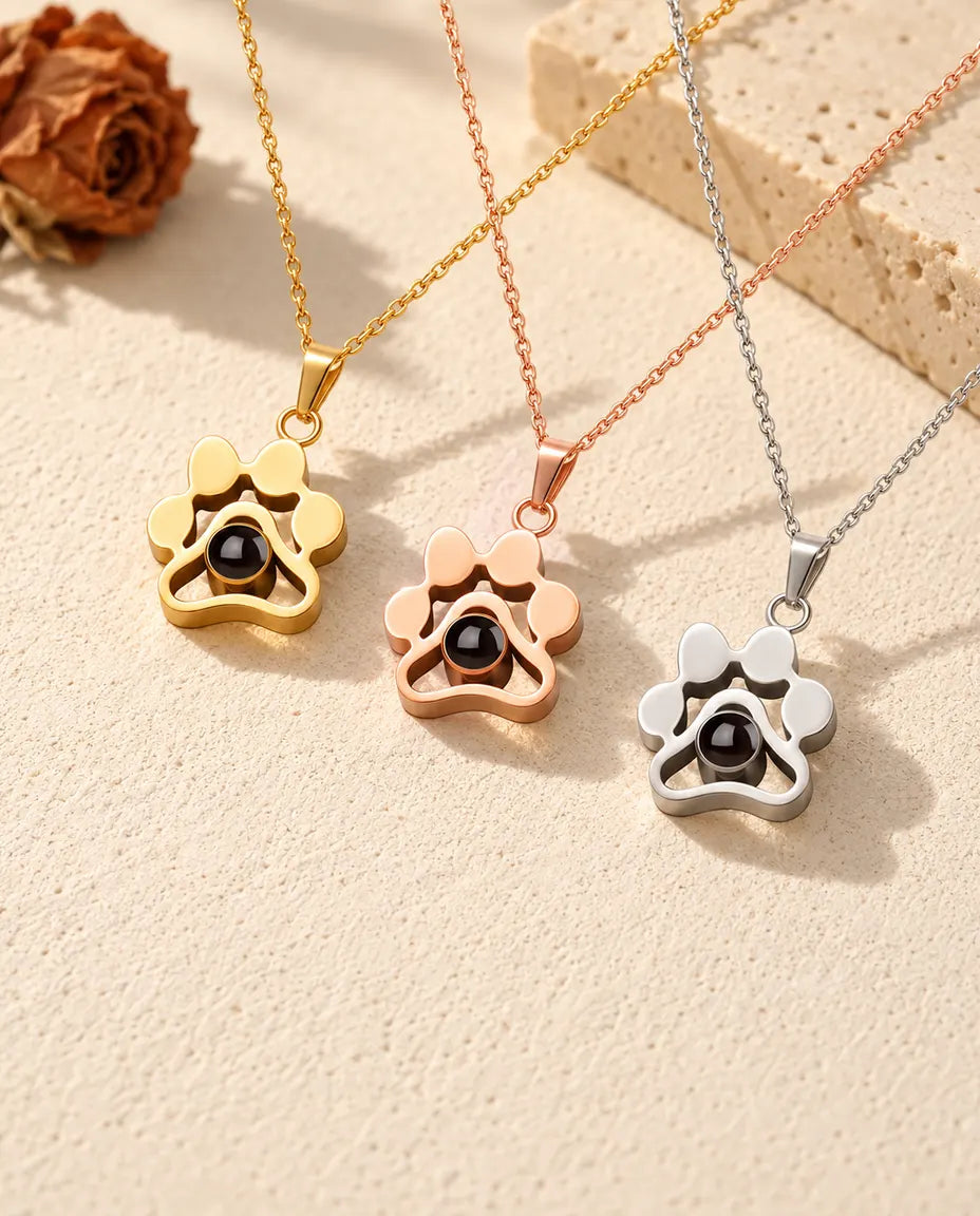 Paw print photo projection necklaces in gold tone, rose gold tone and silver in a row