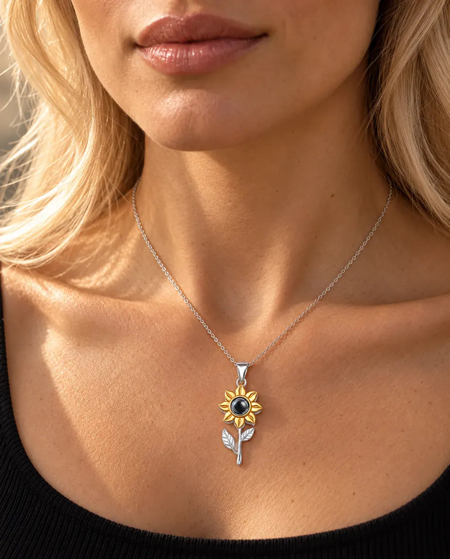 Woman in a black top wearing the sterling silver sunflower on a stem projection necklace