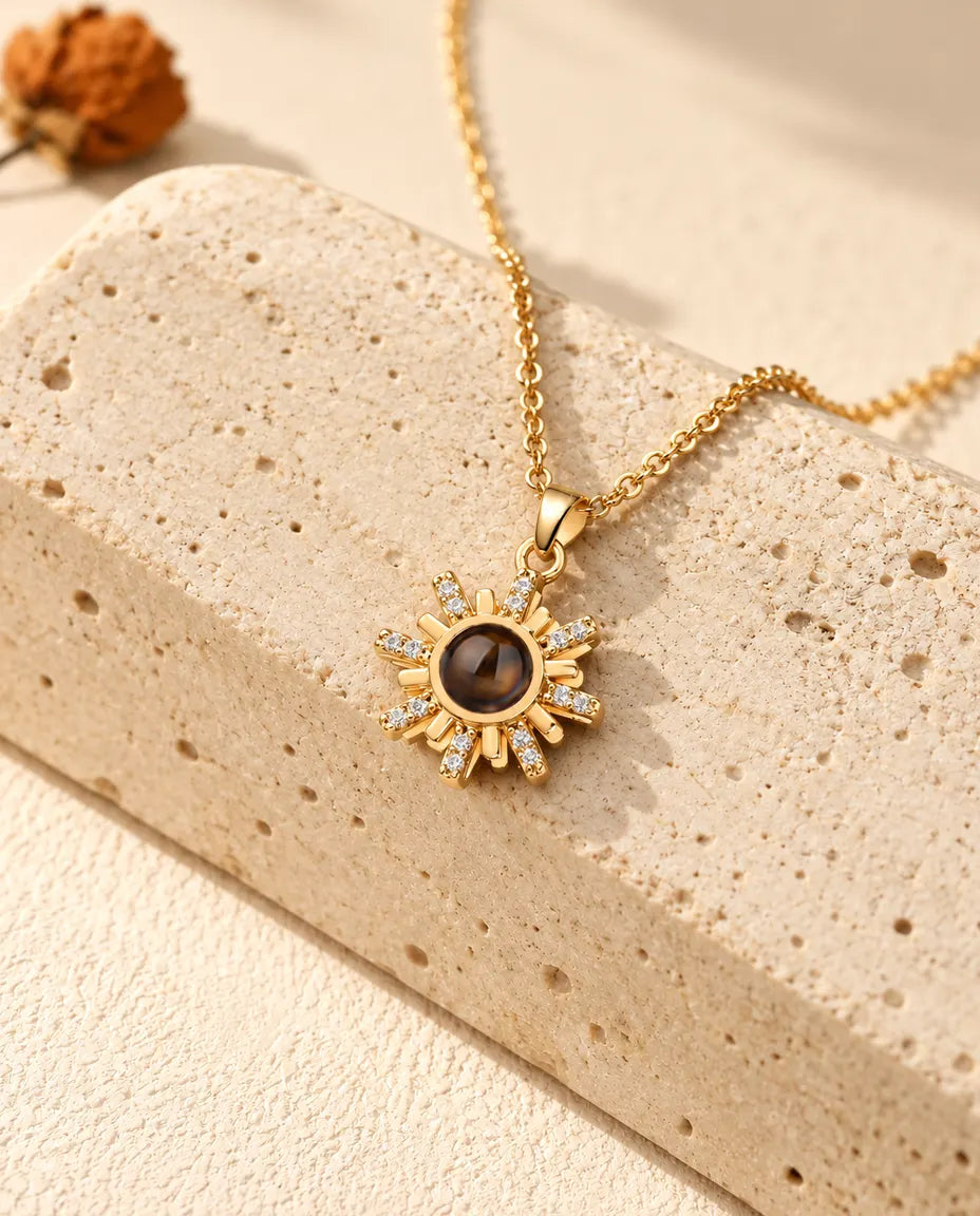 Personalized gold tone sunburst photo projection necklace on a travertine block
