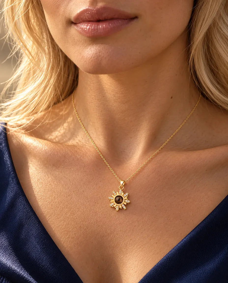Woman in a navy top wearing the gold tone sunburst projection necklace