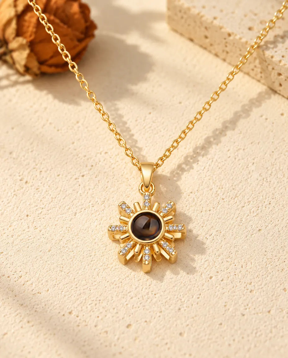 Front view of the gold tone sun pendant with the projection stone at its center