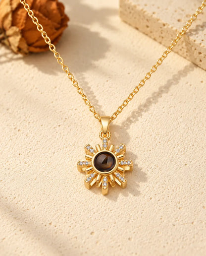 Front view of the gold tone sun pendant with the projection stone at its center