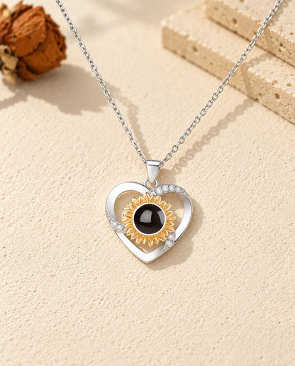 Front view of the silver tone heart with gold tone sunflower and cubic zirconia