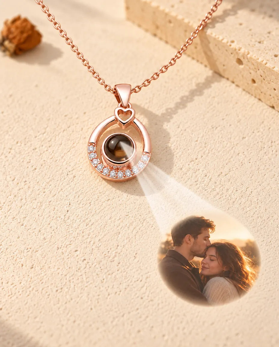 Rose gold tone teardrop necklace projecting a couple photo onto cream plaster