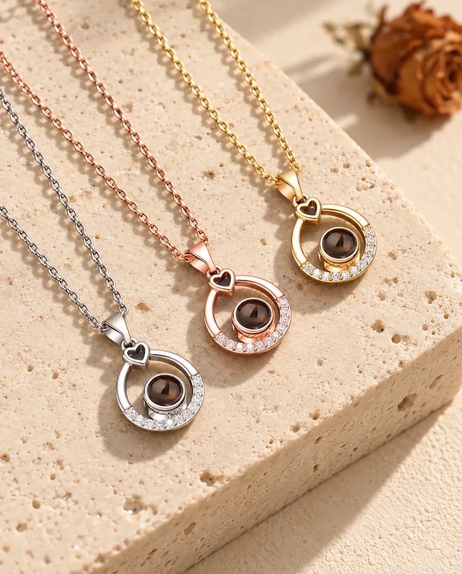 Gold tone, rose gold tone and silver tone open teardrop pendants laid diagonally