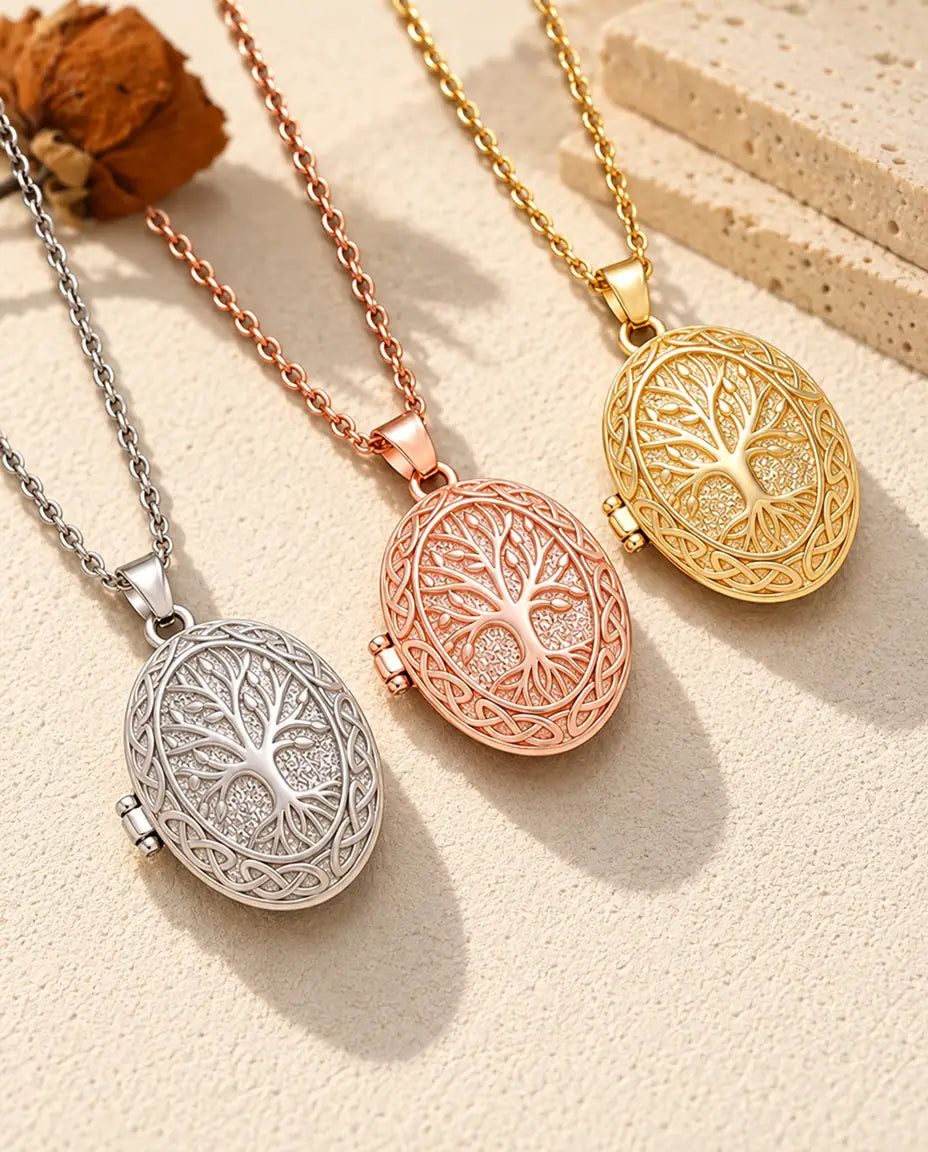 Tree of life photo lockets in silver tone, rose gold tone and gold tone laid diagonally on cream plaster