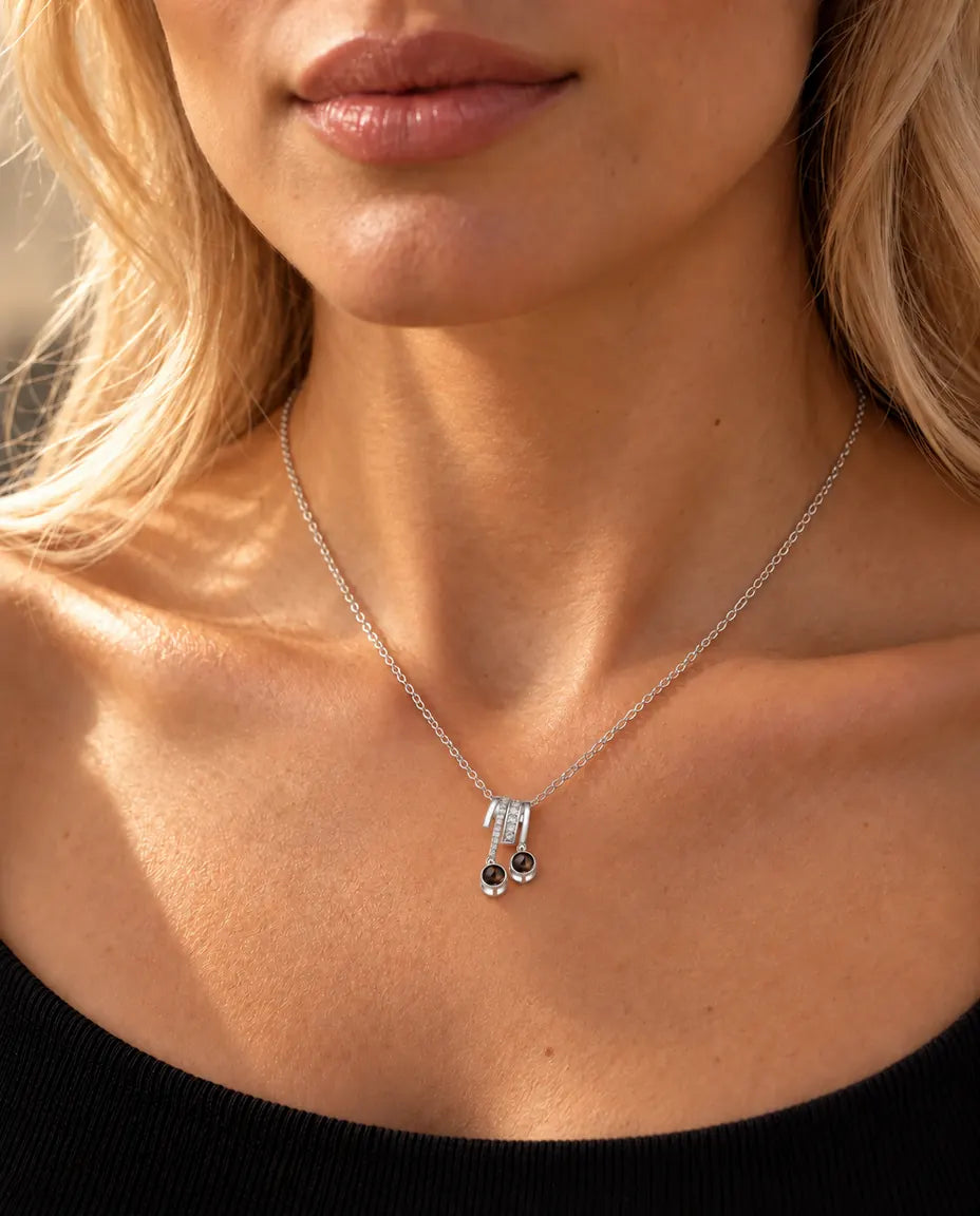 Woman in a black knit top wearing the silver tone two stone photo projection slide necklace