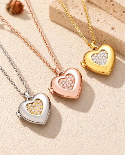 Two-tone pave heart photo lockets in silver tone, rose gold tone and gold tone laid diagonally on cream plaster