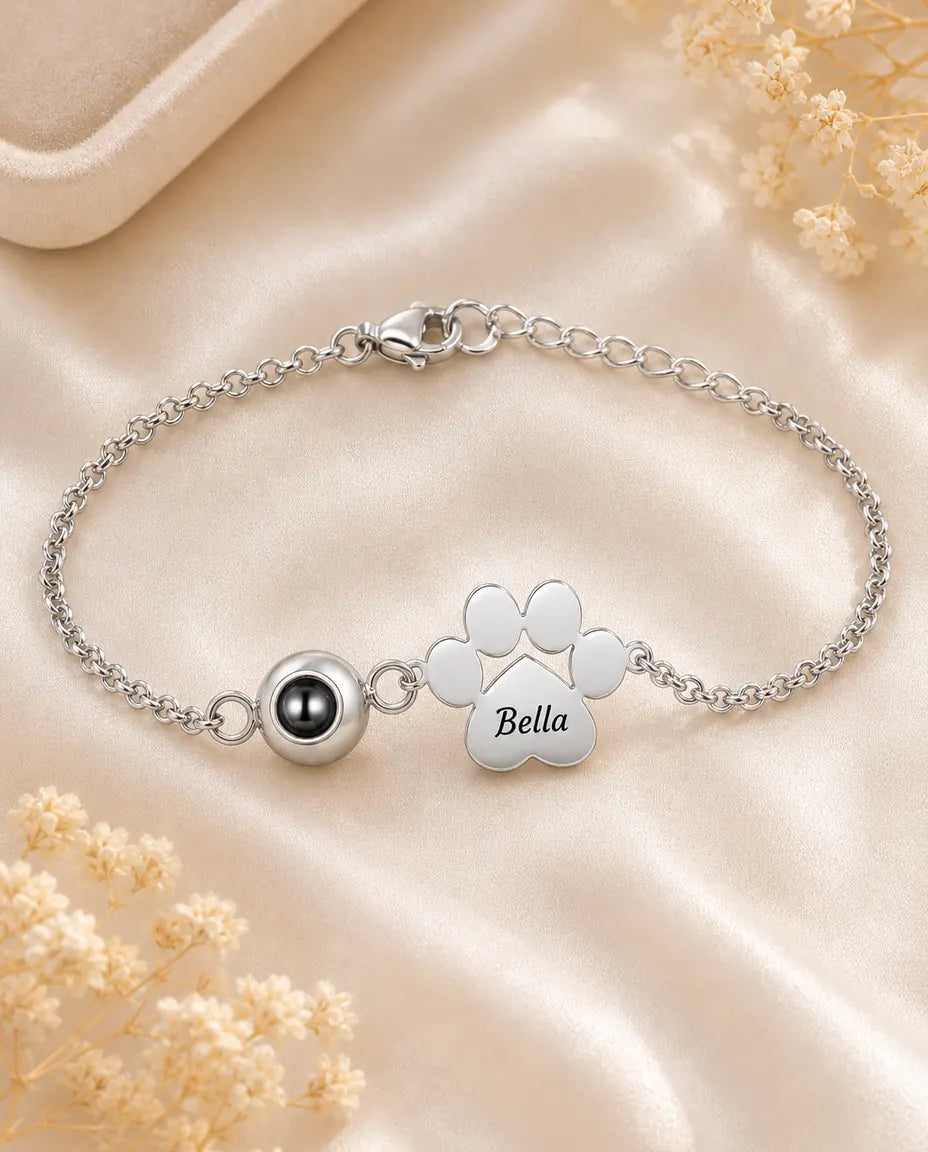 Personalized pet photo projection bracelet in silver with engraved paw print charm on cream silk
