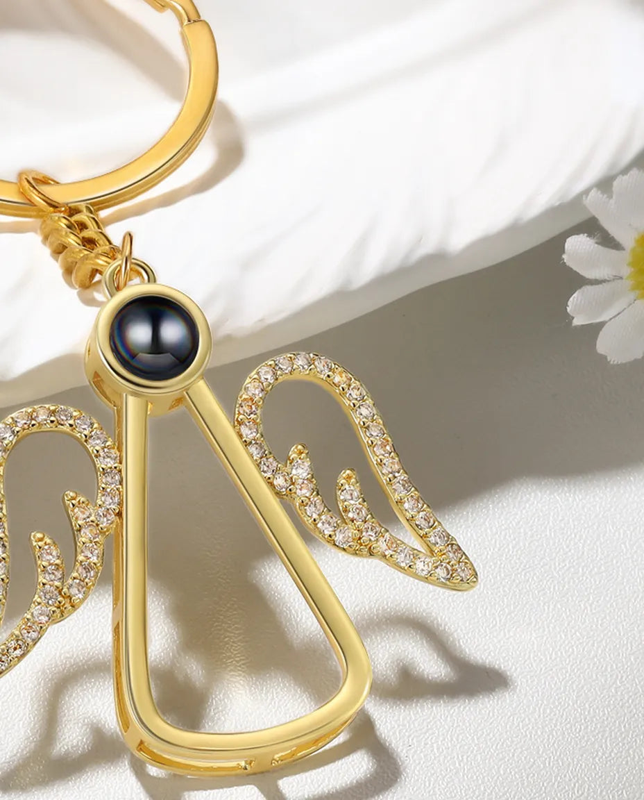 Close-up of the projection bead and pave crystal wings on the angel keychain