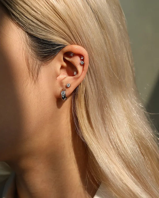 Round Moissanite Stud Earrings in 925 Sterling Silver - worn on a model, wider view of ear and neck
