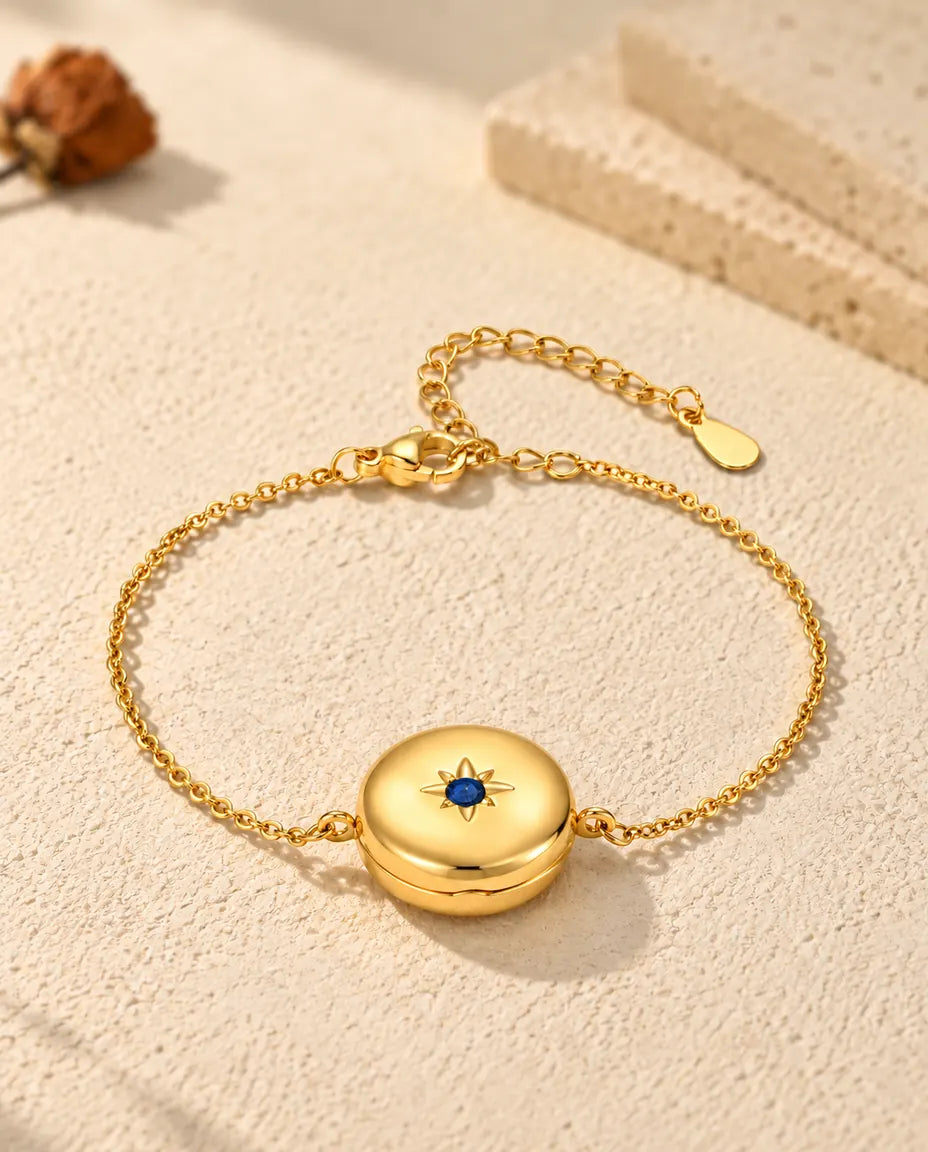 Personalized gold-tone round photo locket bracelet with a birthstone set in a star on the front