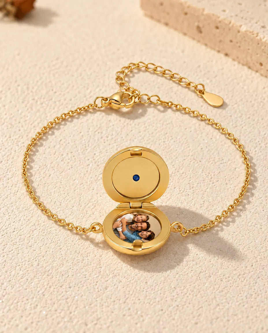 Round locket bracelet open with one photo in the base and a plain gold lid