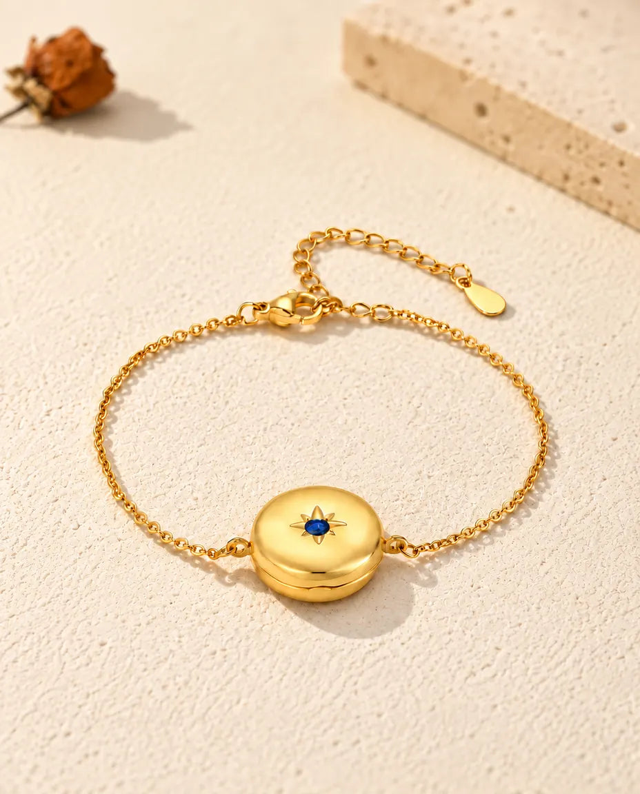 Closed round locket bracelet from a low angle, star-set birthstone on the front
