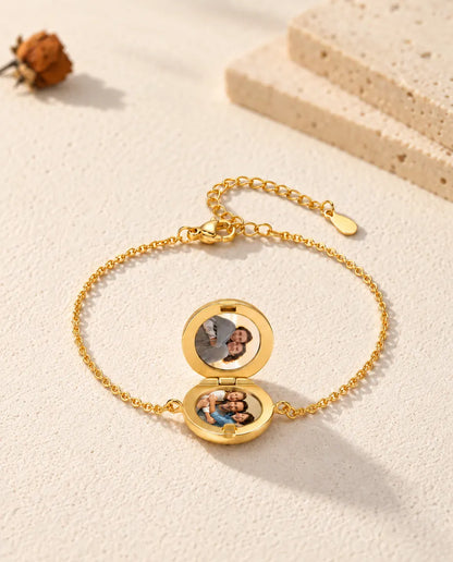 Open round locket bracelet with two photos, seen from a low angle
