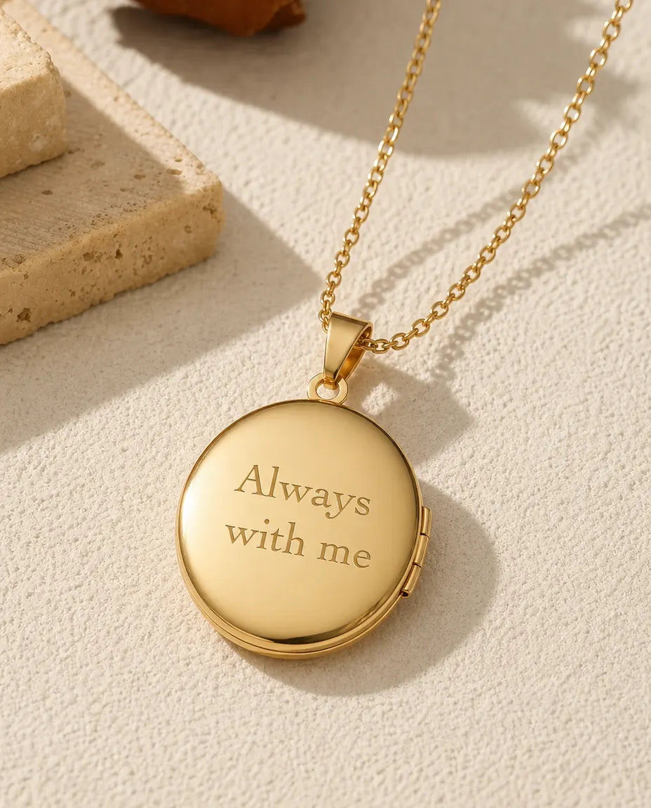 Polished gold back of round locket engraved with Always with me sample text