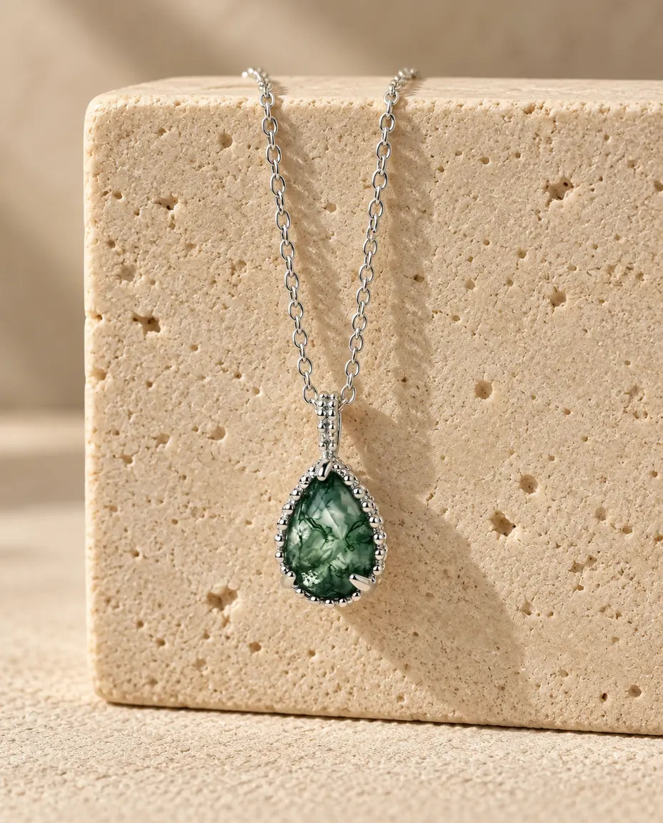 Moss Agate Necklace - displayed on a travertine block