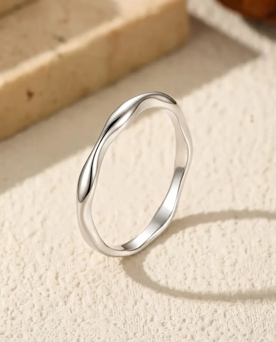 Wavy Band Ring in 925 Sterling Silver - standing upright on a cream textured surface