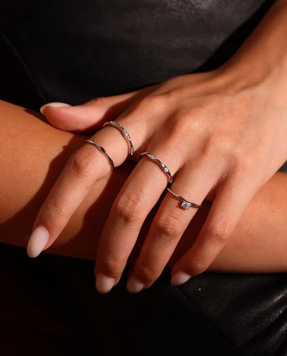 Wavy Moissanite Band Ring in 925 Sterling Silver - worn together with other rings, close-up of the fingers