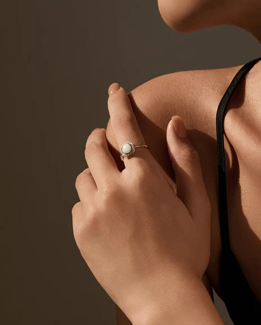 Opal Halo Ring in 925 Sterling Silver - worn on a hand resting on the shoulder
